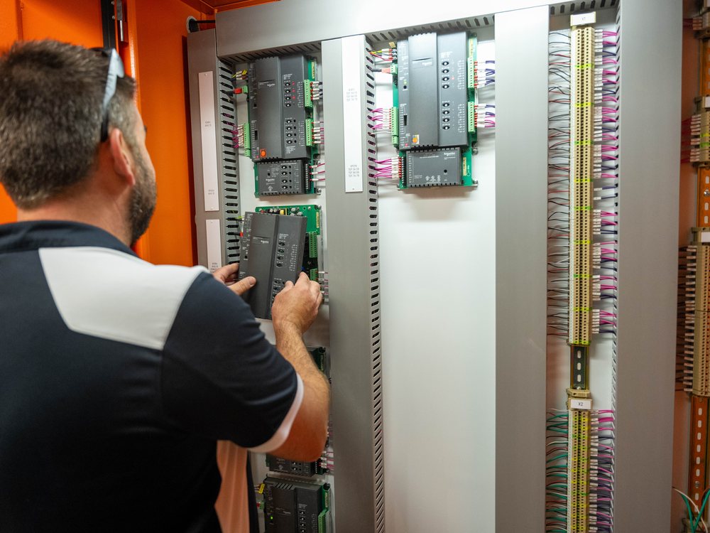 Pristine Cooling technician working on controls in a plant room on a Goldfields commercial build